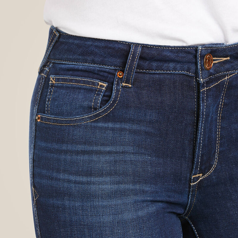 Close-up of blue jeans with a beige background