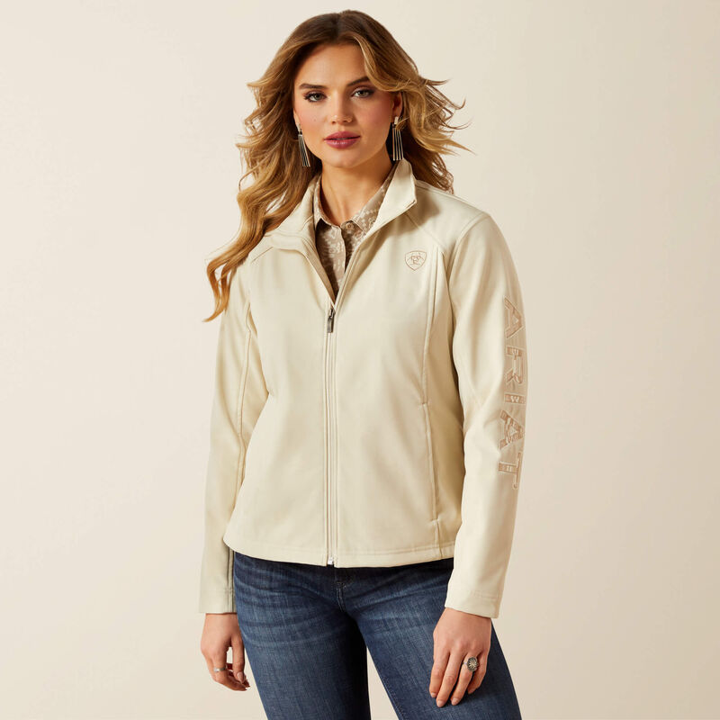 Woman wearing a beige jacket and blue jeans on a beige background