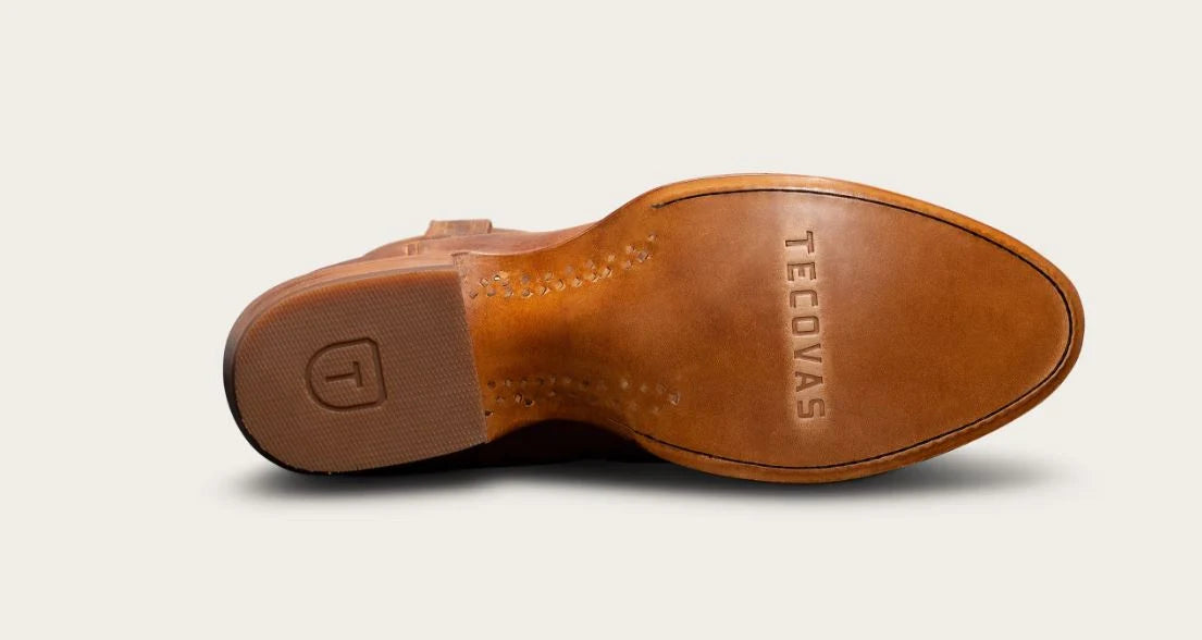 A close-up of the tan leather underside of a shoe, showing the VEVORAS brand name embossed on the toe area and a brown rubber heel.