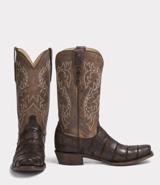 Pair of brown cowboy boots with intricate designs on a white background
