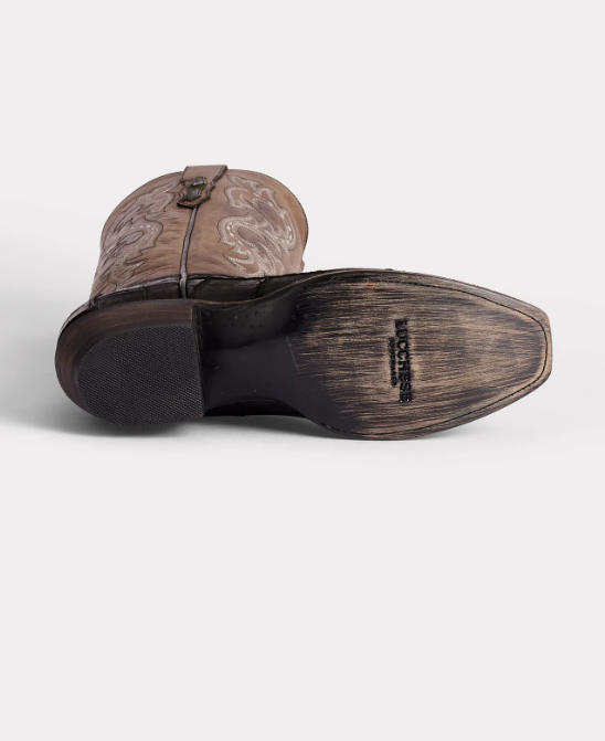 Brown cowboy boot with embossed design on a white background