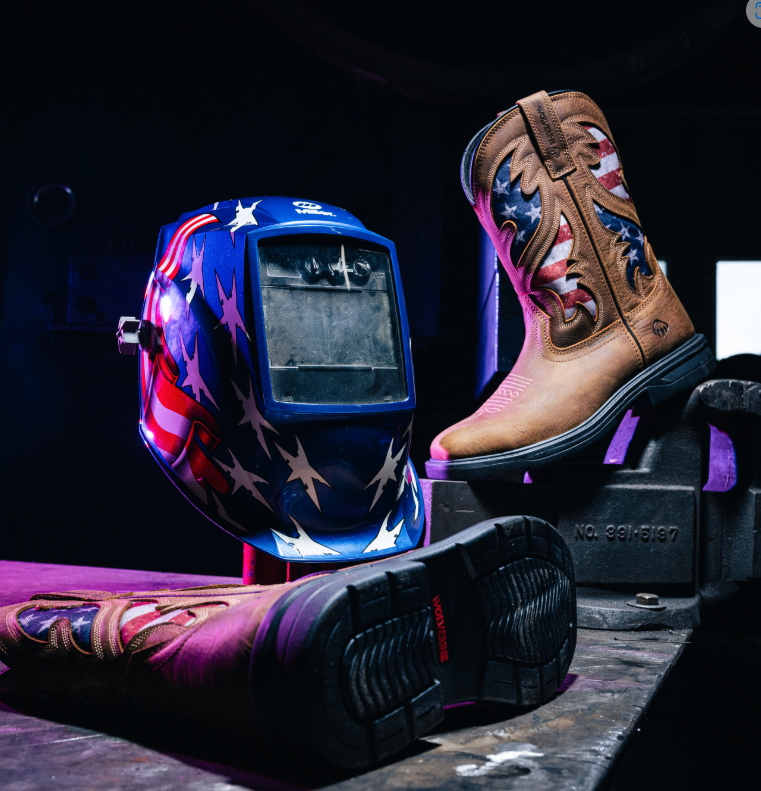 Welding helmet and boots with American flag design on a dark background