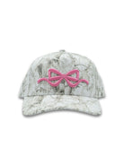 Camo-patterned cap with a pink bow design on a white background