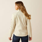 Woman wearing a beige jacket on a plain background