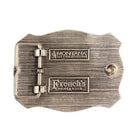 A silver-toned metal buckle with a textured brushed finish, featuring two engraved rectangular plates that read 'Montana' and 'French's' with smaller text below, photographed on a dark surface.