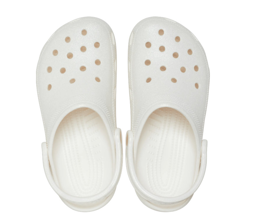 White clogs with gold polka dot pattern on a white background