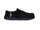 Black slip-on shoe with a small green tag on a white background