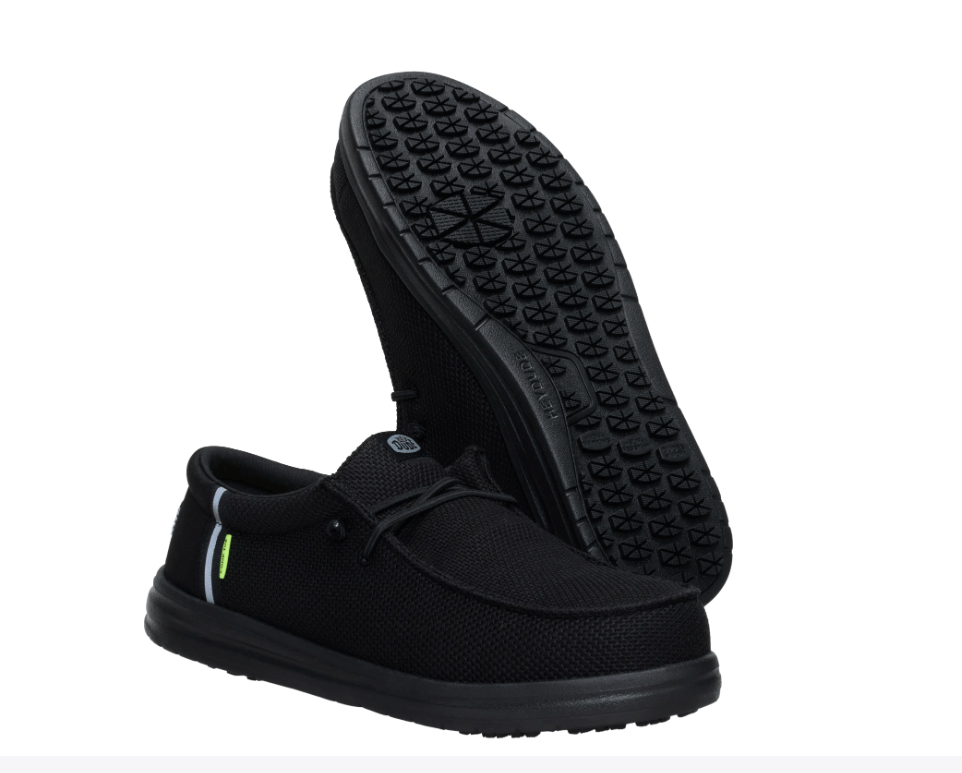 Black slip-on shoes with textured sole on a white background