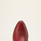 Close-up of the pointed toe of a red leather boot against a plain off-white background.