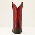 A single red leather cowboy boot shown from the back, featuring a dark brown stacked heel and a subtle tonal western pattern on the shaft, set against a plain off-white background.