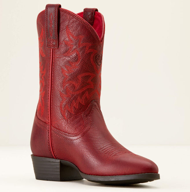 A single red leather cowboy boot with embossed floral detailing on the shaft, a dark brown stacked heel, and a square toe, photographed against a plain off-white background.