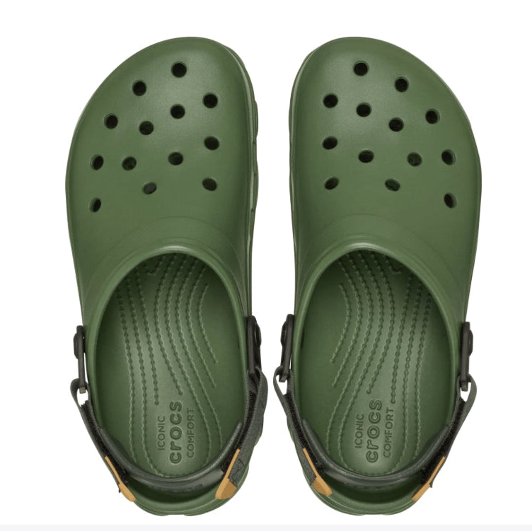 Green clogs with black straps on a white background