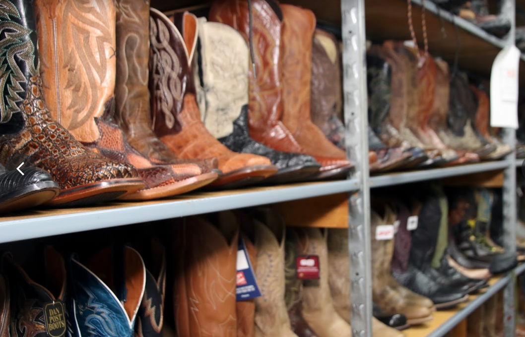 Row of western boots on a rack.