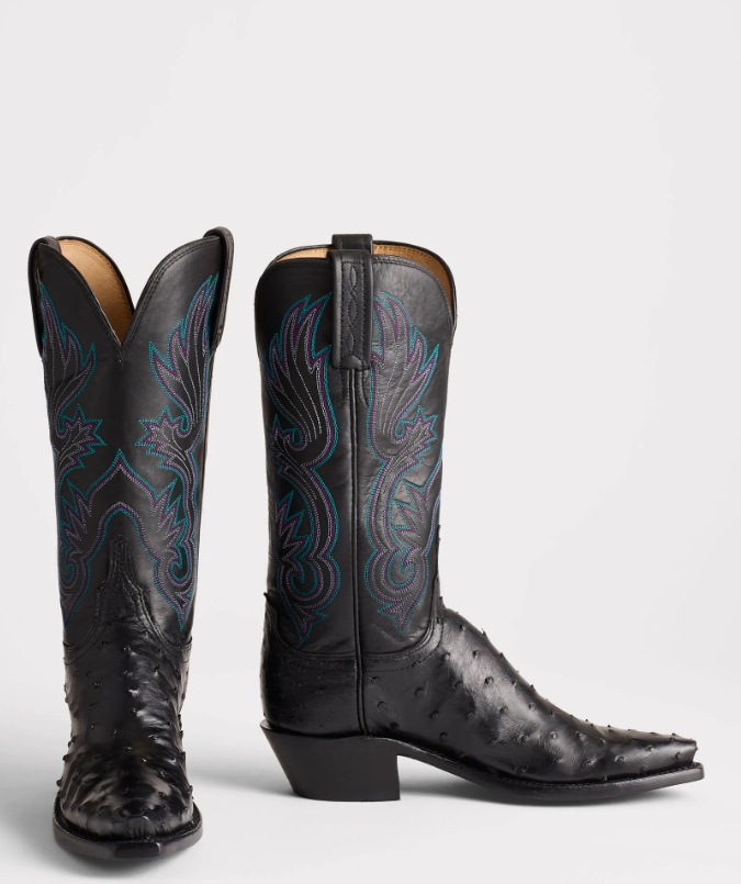 Pair of black cowboy boots with intricate designs on a white background